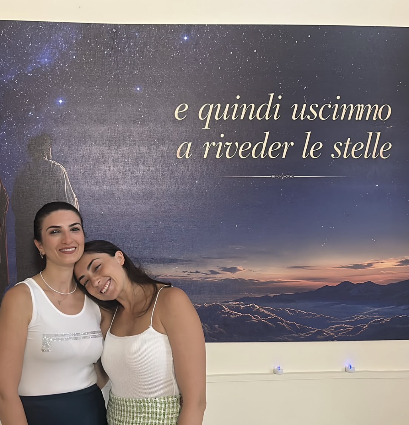 Due visitatrici nella sala di Gallipoli, davanti alla parete stellata con il verso «e quindi uscimmo a riveder le stelle».